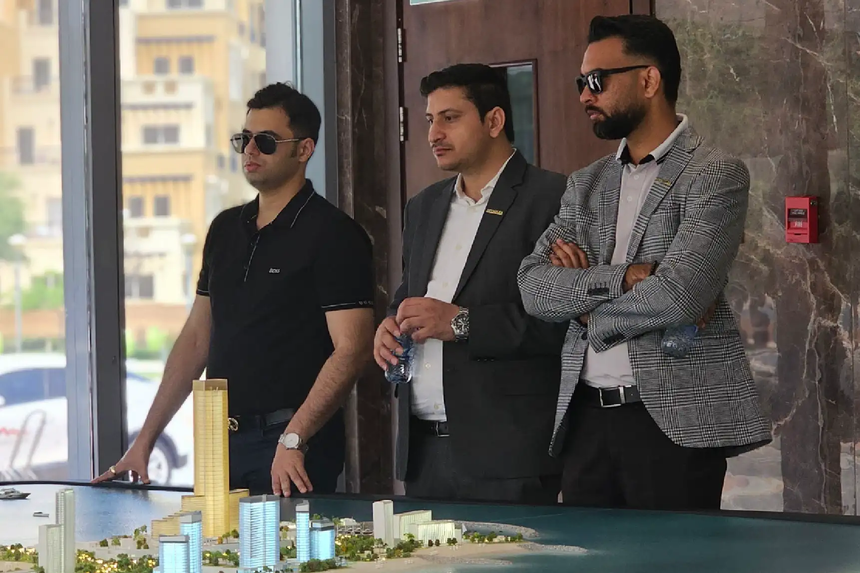 Two professionals in business attire discussing legal documents with a laptop, a gavel, and scales of justice on the table
